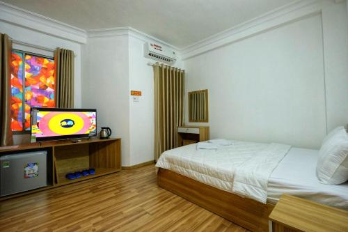 a hotel room with a bed and a television at City Backpackers Hostel in Ho Chi Minh City