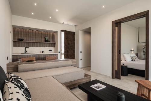 een woonkamer met een bank en een bed bij AKU Suites with private pools in Stalida