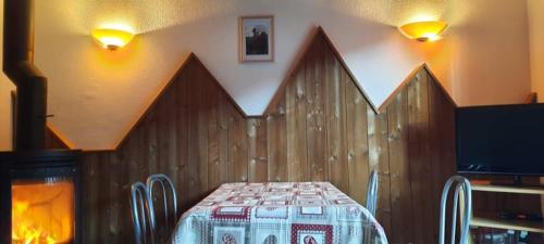 une salle à manger avec une table et une télévision dans l'établissement Résidence Vologne, à La Bresse