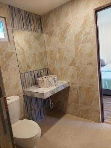 een badkamer met een toilet en een douche bij แสงหิรัญ บีช รีสอร์ท in Pran Buri