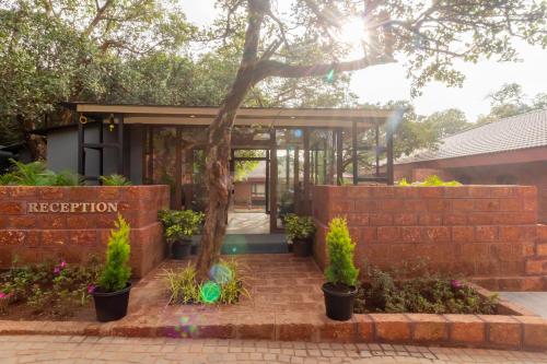 a garden entrance to a building with a brick wall at R R Heritage Resort Pure Vegetarian in Mahabaleshwar
