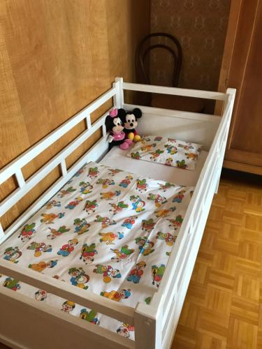 a bed with two stuffed animals sitting on it at Blattenheimat - im traditionellen Appenzeller Haus in Appenzell