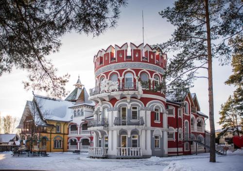 una gran casa roja y blanca en la nieve en V Nekotorom Tsarstve Hotel, en Riazán