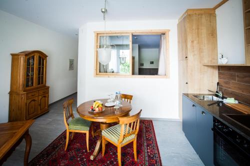 a kitchen with a wooden table and chairs at Carlton-Europe Vintage Adults Hotel in Interlaken