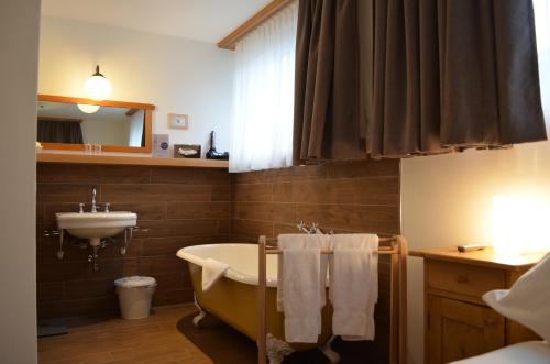 La salle de bains est pourvue d'une baignoire et d'un lavabo. dans l'établissement Carlton-Europe Vintage Adults Hotel, à Interlaken