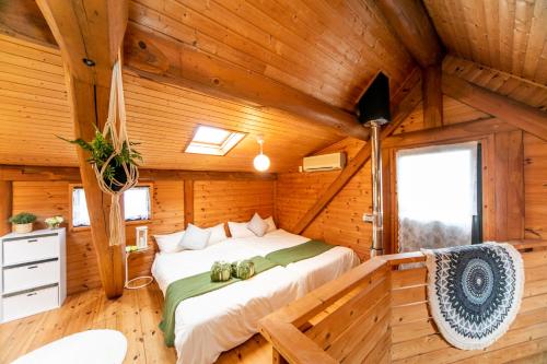 1 dormitorio en una cabaña de madera con 1 cama en Awaji Seaside Log House, en Awaji