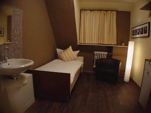 ein kleines Schlafzimmer mit einem Bett und einem Waschbecken in der Unterkunft Hotel Palatino in Sundern