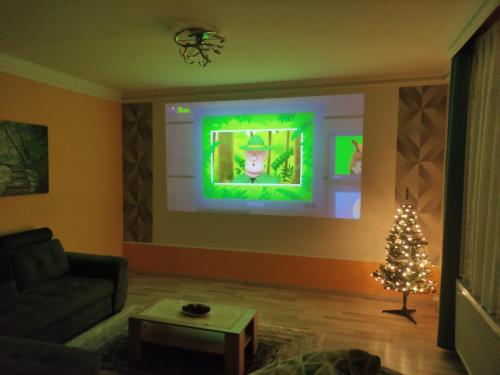 a living room with a christmas tree and a tv at Pilis Apartman in Piliscsaba