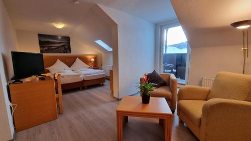 a hotel room with a bed and a living room at Hotel Magdalenenhof inklusive MeineCardPlus in Willingen