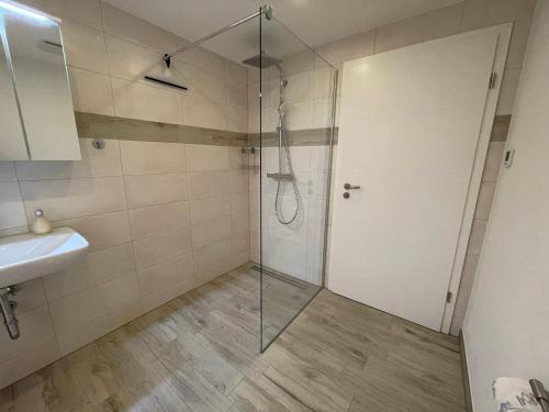 eine Dusche mit Glastür neben einem Waschbecken in der Unterkunft Ferienwohnung Am Südhang in Göhren
