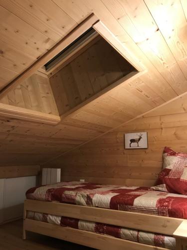 a bed in a room with a wooden ceiling at La Grande Ourse - 4 pièces, 6 personnes in Méribel