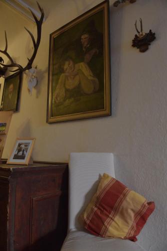 a painting on a wall next to a white couch at Gasthof Hirschenwirt in Schöder