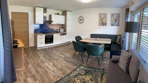 een woonkamer en een keuken met een tafel en stoelen bij NeuhausLiving in Aschau