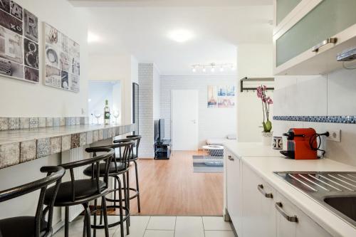 a kitchen with white cabinets and bar stools at Grand Budapest Penthouse in Budapest