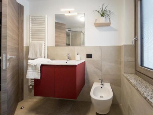 uma casa de banho com um lavatório vermelho e um WC. em La Maison de Papagran CIR Charvensod-0007 em Aosta