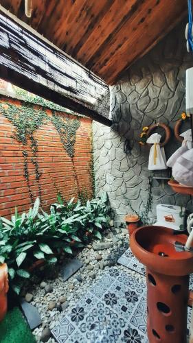 a bathroom with a toilet and a stone wall at Mekong Pottery Homestay, Green-Friendly & Boat Tour in Vĩnh Long