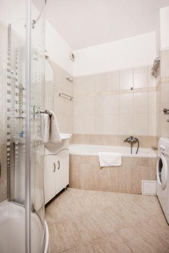 a bathroom with a tub and a sink and a shower at Grand Budapest Penthouse in Budapest