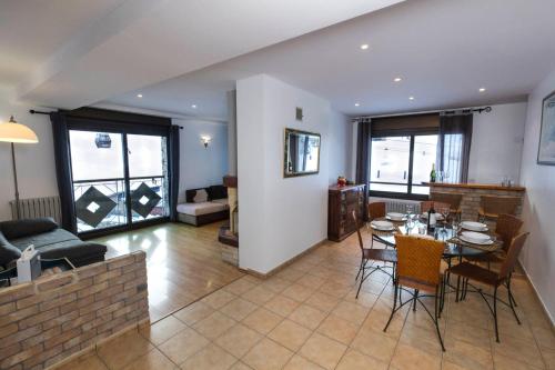 a living room with a table and chairs and a couch at Superbe appartement 170m2 pied des pistes de ski. in Pas de la Casa