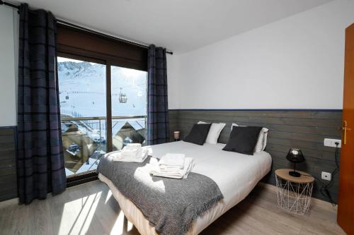 a bedroom with a large bed and a large window at Superbe appartement 170m2 pied des pistes de ski. in Pas de la Casa