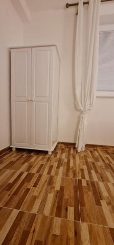 an empty room with a white door and wooden floors at Domček 22 in Dudince