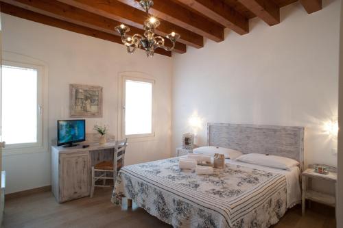 a bedroom with a bed and a desk and a television at Villa Myosotis in Mirano