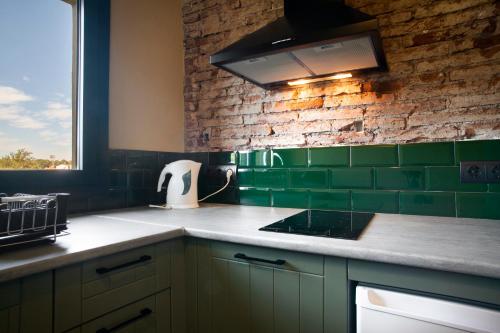 a kitchen with green tiles on the wall at Priorat Aparthotel in Falset