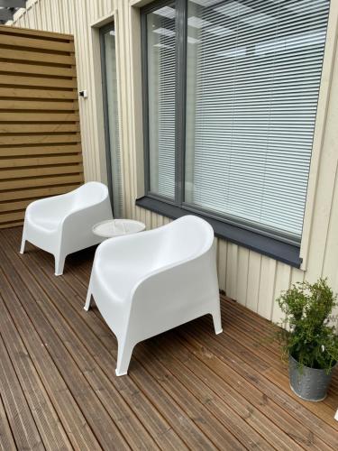 two white chairs sitting on a porch at Rivitalohuoneisto in Kokkola
