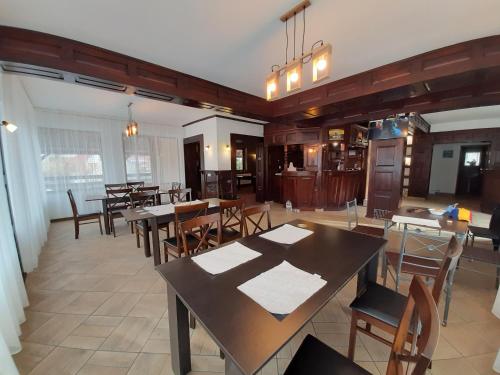 a dining room with wooden tables and chairs at Pensiunea Montan din Bran,sat Simon SPA indoor in Bran