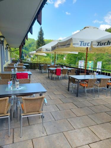 a patio with tables and chairs and umbrellas at Hotel Landgasthof Frankenstern in Gößweinstein