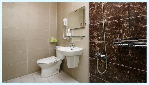 La salle de bains est pourvue de toilettes, d'un lavabo et d'une douche. dans l'établissement 小敏&日森民宿, à Jian