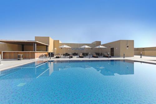 una gran piscina frente a un edificio en TIME Asma Hotel, en Dubái