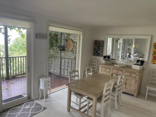 een eetkamer met een tafel en stoelen en een balkon bij Villa Provincial, Cypress Lakes Resort, Two Bedrooms both with Private Ensuites, 2 KING or 4 SINGLE BEDS, Sensational Views in Pokolbin