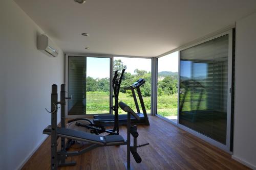 ein Fitnessstudio mit zwei Laufbändern und einem großen Fenster in der Unterkunft Quinta Da Agra in Ponte de Lima