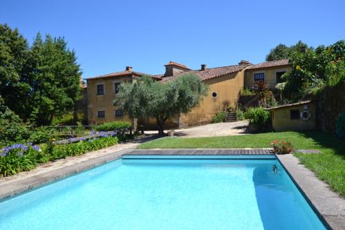 a swimming pool in the yard of a house at Quinta Da Agra in Ponte de Lima