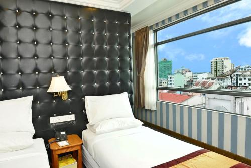 سرير أو أسرّة في غرفة في Hotel Grand United - 21st Downtown