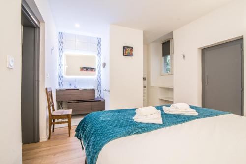 une chambre blanche avec un lit avec des serviettes dessus dans l'établissement Nouveau - L'Intemporel - Centre Ville, à Phalsbourg