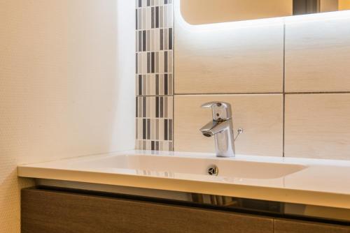une salle de bain avec un lavabo et un miroir dans l'établissement Nouveau - L'Intemporel - Centre Ville, à Phalsbourg