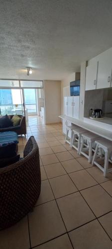 a living room with a table and a kitchen at MARGATE BOULEVARD SPACIOUS APARTMENT in Margate