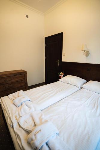 a bedroom with a large bed with towels on it at Willa 654 in Szklarska Poręba