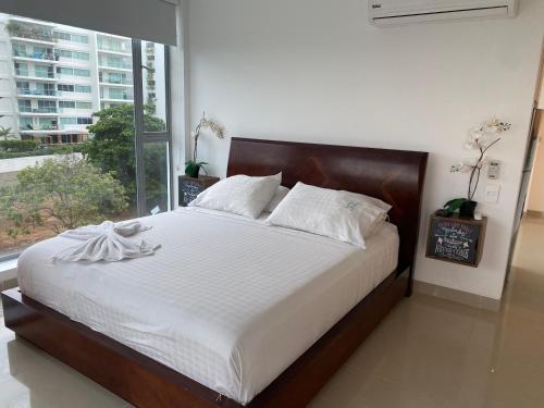 a bedroom with a large bed with a large window at Playa la Boquilla, Apto dentro Condominio Hotel Sonesta in Cartagena de Indias