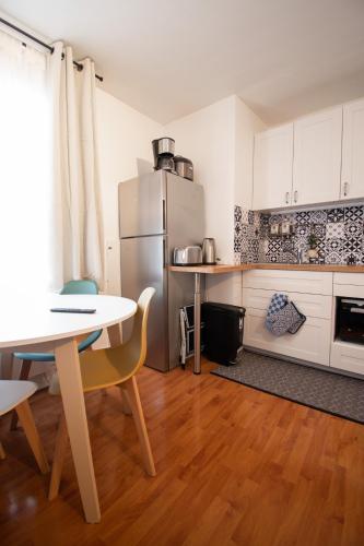 une cuisine avec une table et un réfrigérateur dans l'établissement Appartement 2 pièces chic à Paris, à Gentilly