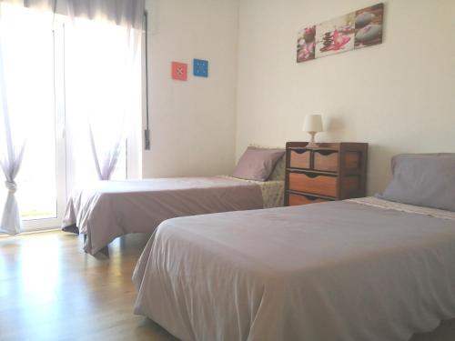 a bedroom with two beds and a window at Casa Moinhos do Mar in Ericeira