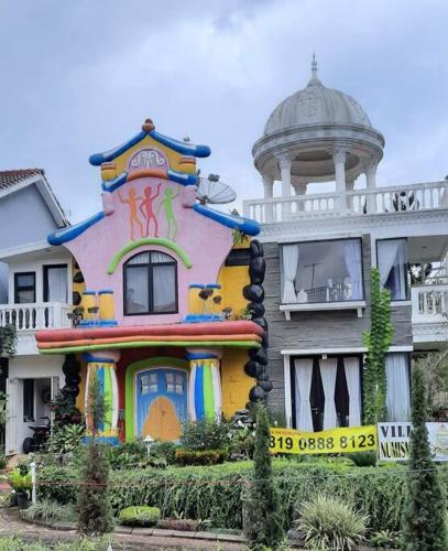 a house with a painting on the front of it at Villa Numismatik. Penginapan Unik yang Asri Alami in Cikundul