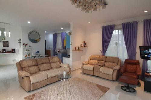 a living room with two couches and a tv at Villa Numismatik. Penginapan Unik yang Asri Alami in Cikundul