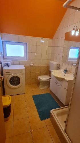 a bathroom with a toilet sink and a washing machine at Valant Apartment in Bled