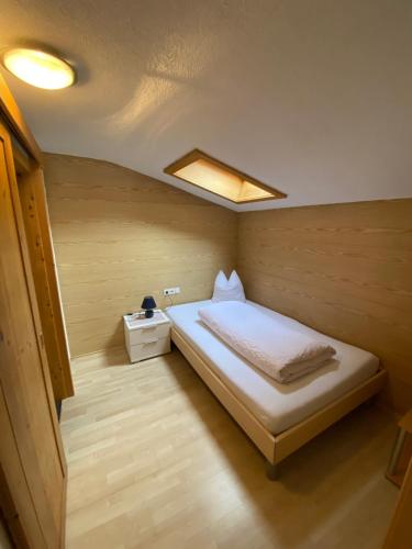a small bedroom with a bed in a room at Pension Bucher in Schnann