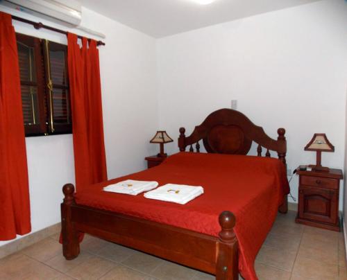 a bedroom with a bed with a red bedspread at Portal De Los Valles in Chicoana