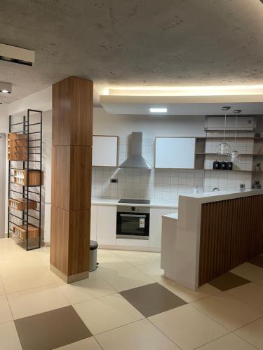 une cuisine avec des armoires blanches et une cuisinière dans l'établissement Leo lux 1, à Niš