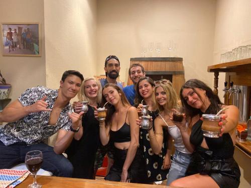 a group of people posing for a picture with wine glasses at Parla Hostel in Buenos Aires
