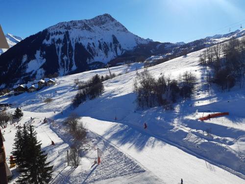 a snow covered slope with a mountain in the background at T2 vue piste Résidence Vostok Zodiaque in Le Corbier